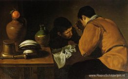 Twee jonge mannen eten aan een bescheiden tafel Twee jonge mannen eten aan een bescheiden tafel