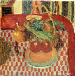 Mand en bord met fruit op een rood geruit tafelkleed Mand en bord met fruit op een rood geruit tafelkleed